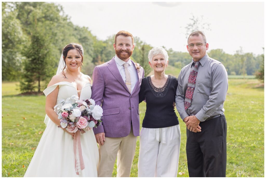 bride and groom posing with family at Findlay, Ohio wedding venue