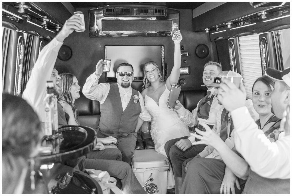 full wedding party going to the reception in a large party bus 