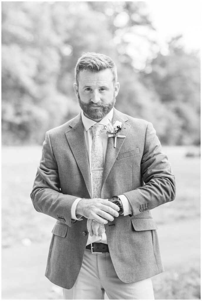 portrait of the groom checking his watch outside after the wedding ceremony 