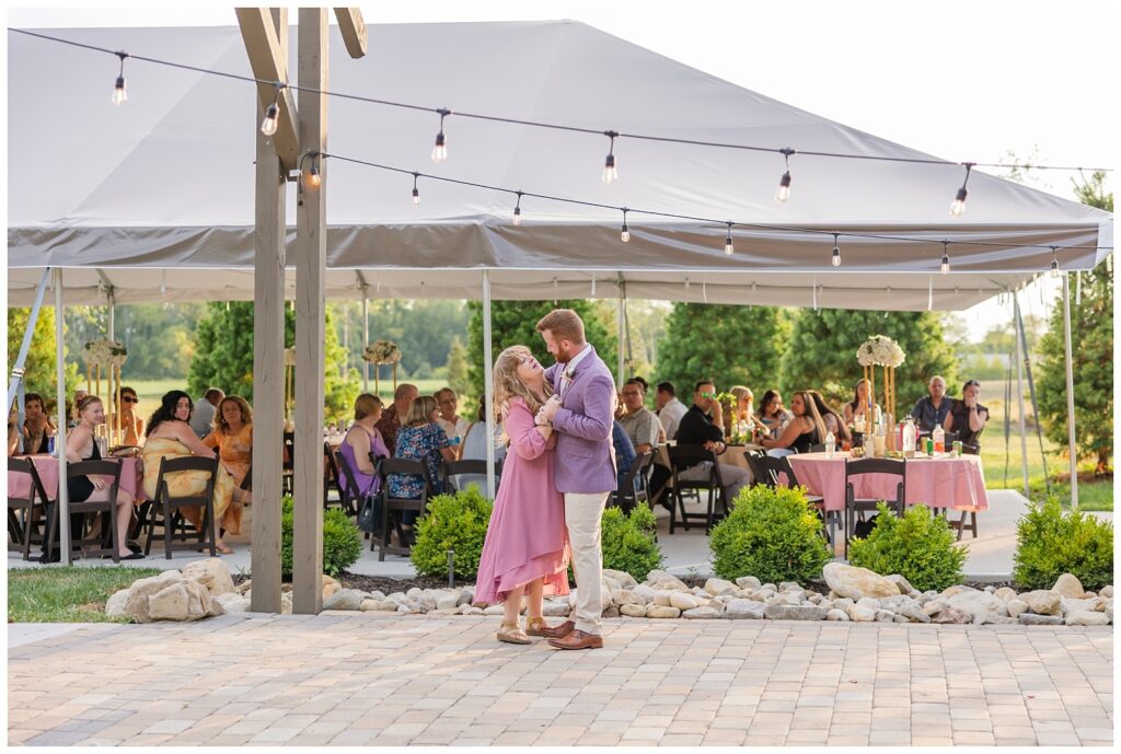 groom dancing with his mom on the patio during reception outside 