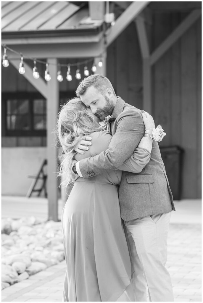 groom hugging and dancing with his mom on the patio during reception outside 