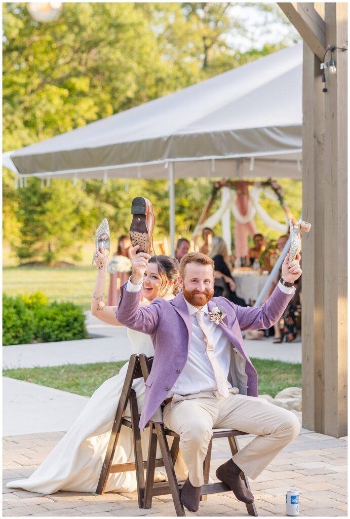 bride and groom participating in the shoe game on the outdoor patio during reception