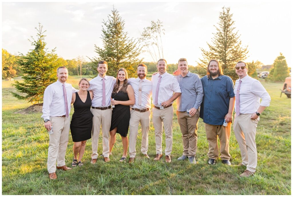 groom posing with his groomsmen and friends from high school during wedding reception