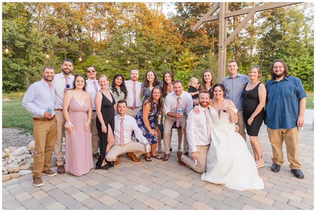 bride and groom posing with a bunch of wedding guests on the outside patio