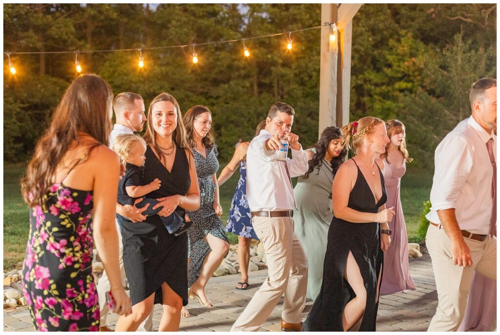 wedding guests dancing outside under the patio lights at Ohio reception venue