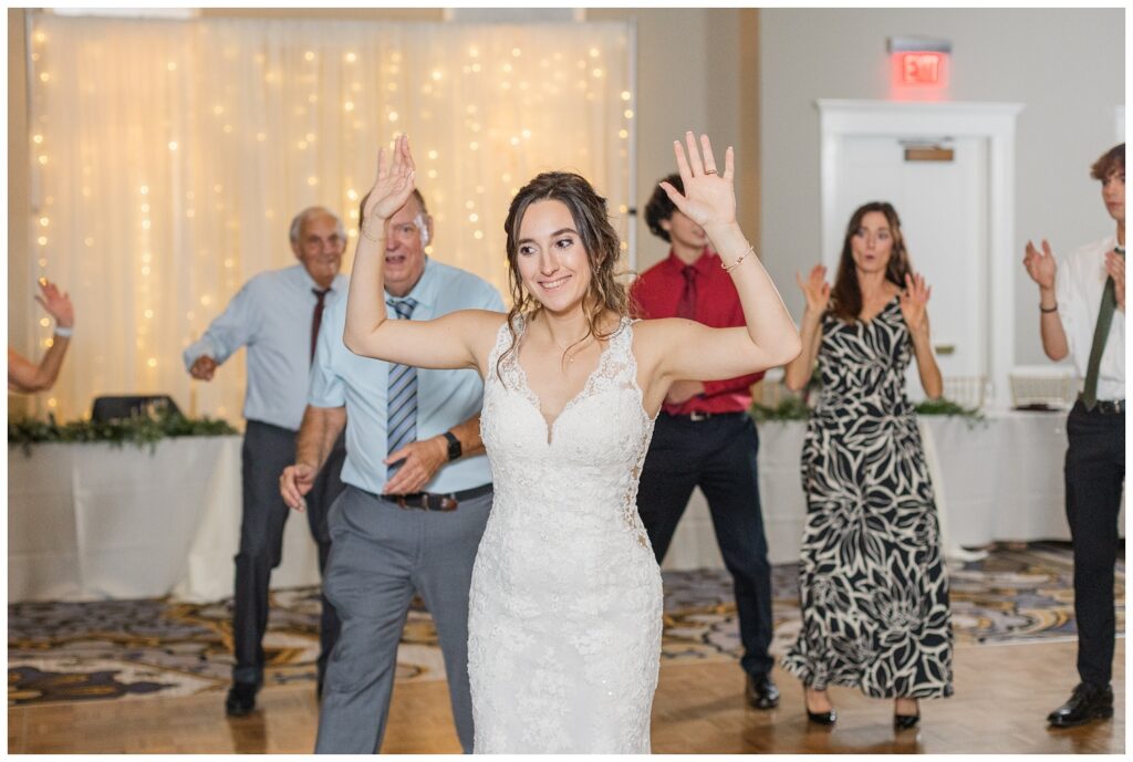 bride dancing in the middle of a circle at hotel wedding reception 