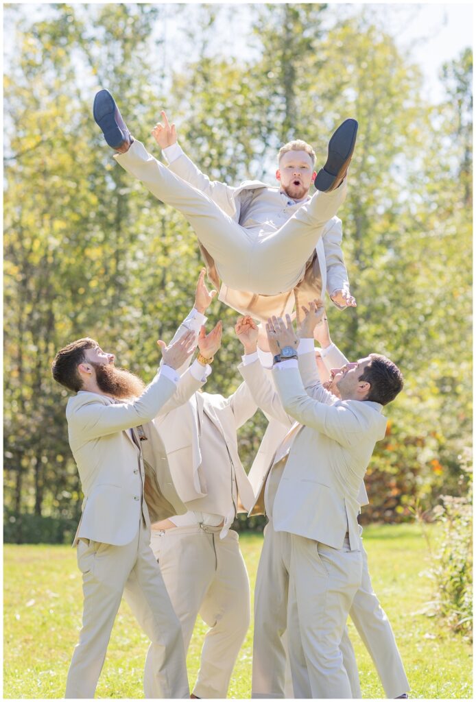 groomsmen throwing the groom up in the air at Bradner Preserve