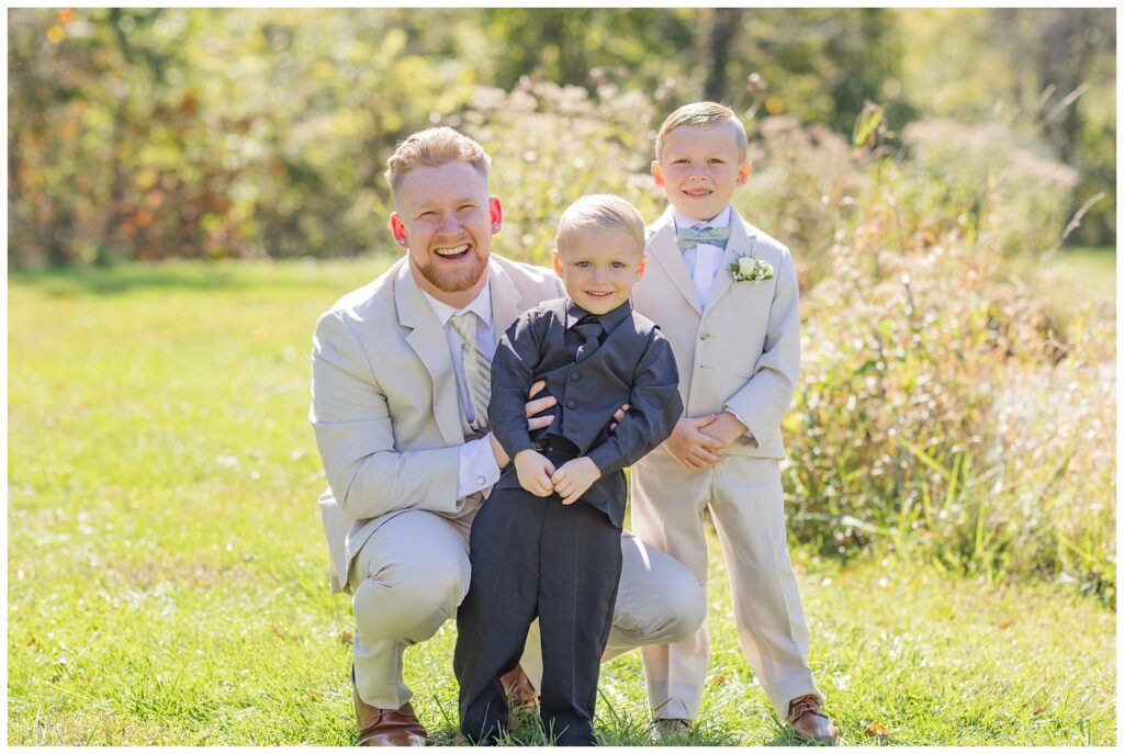 groom kneeling down with the ring bearer and junior groomsmen at Bradner Preserve