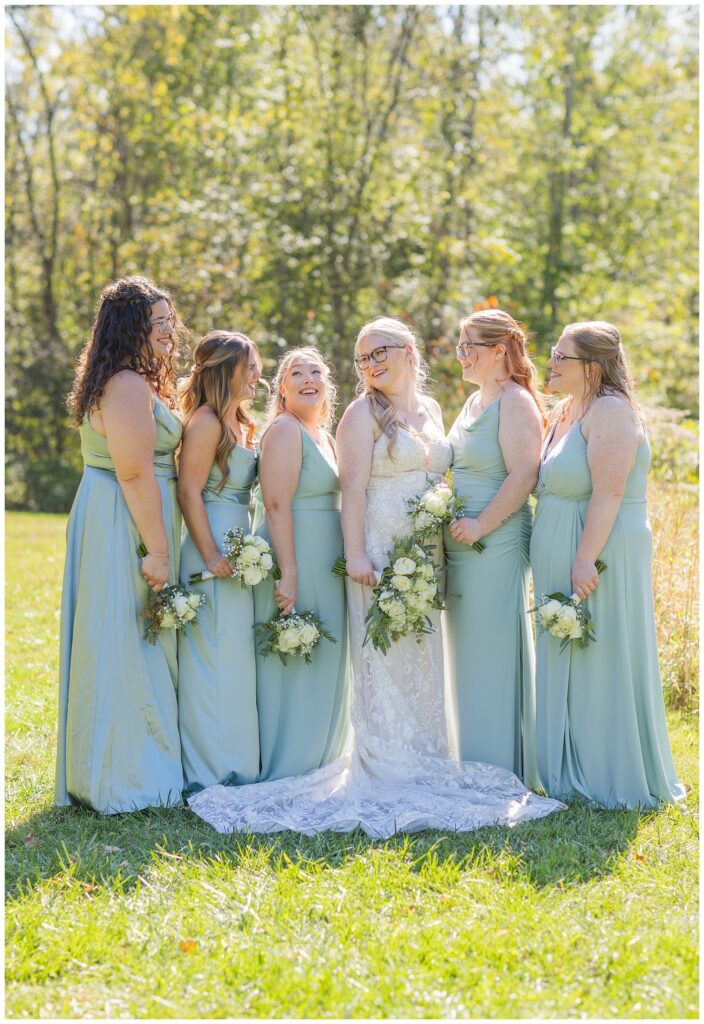 bridal party laughing and holding their bouquets at Bradner Preserve