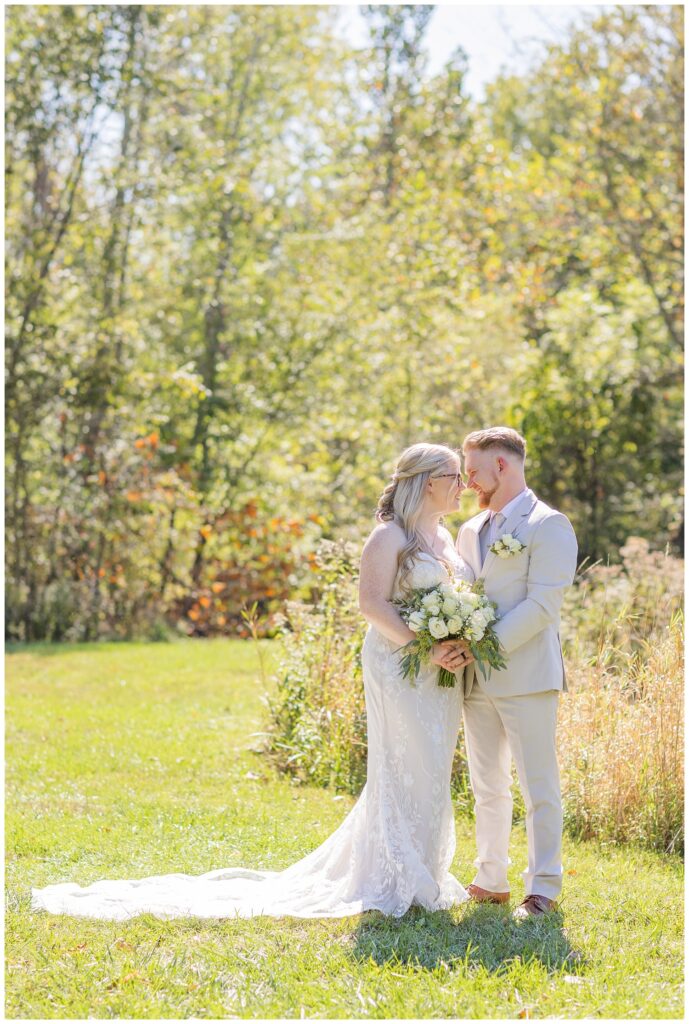 wedding couple touching noses next to tall grass field at Bradner Preserve