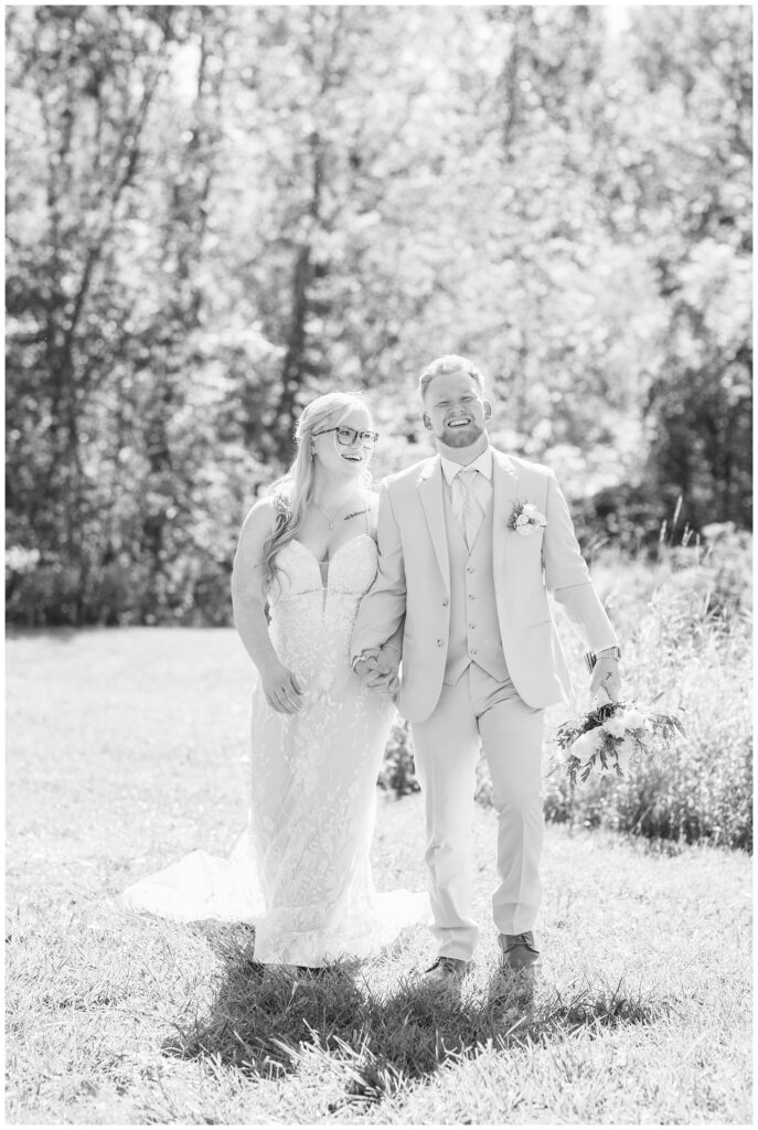 bride and groom walking hand in hand and laughing at Bradner Preserve