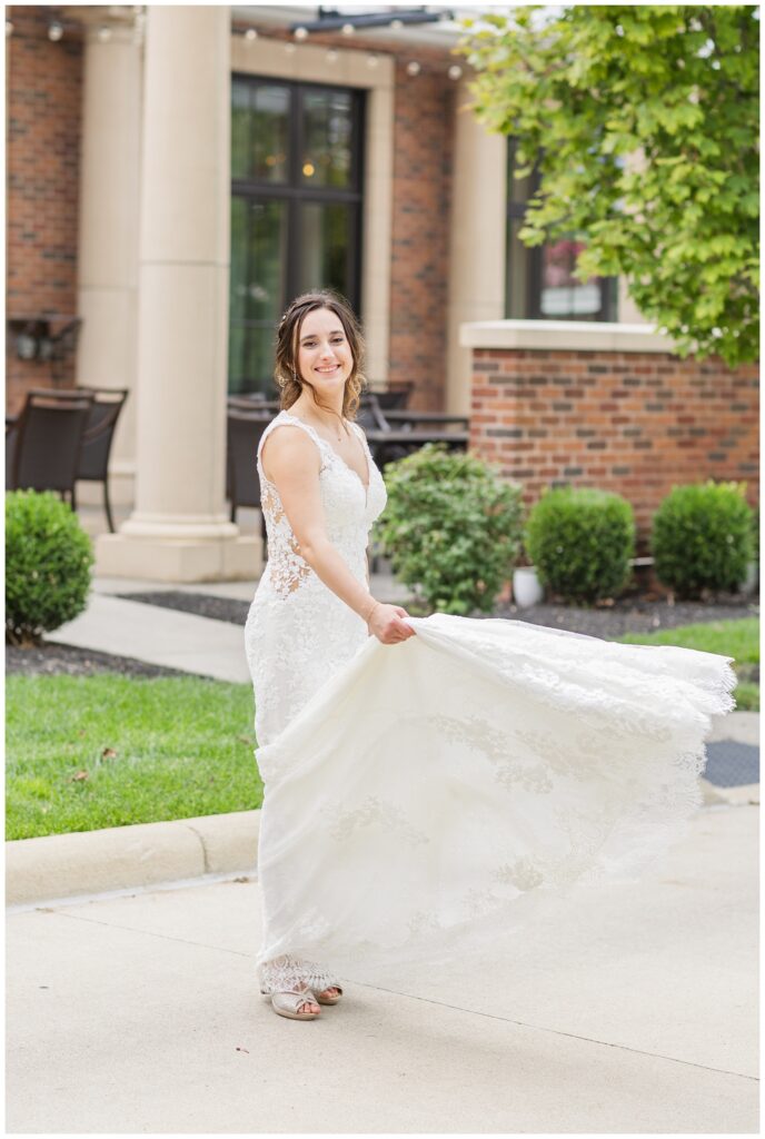 bride tossing the train of her wedding dress outside before the ceremony 