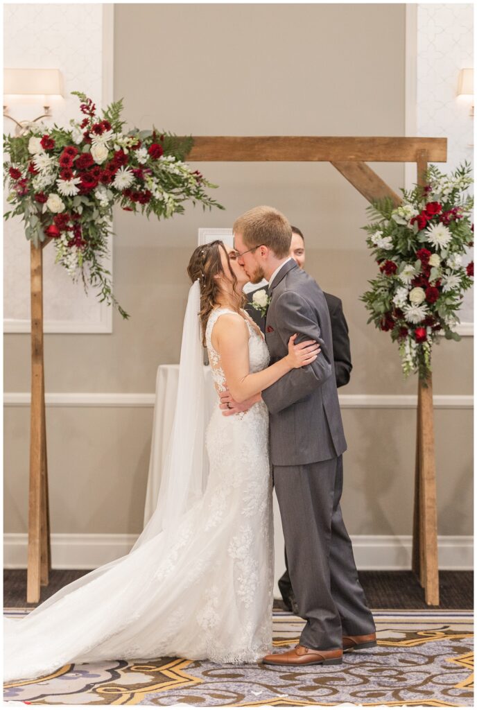 bride and groom kissing at the end of the ceremony at fall hotel wedding