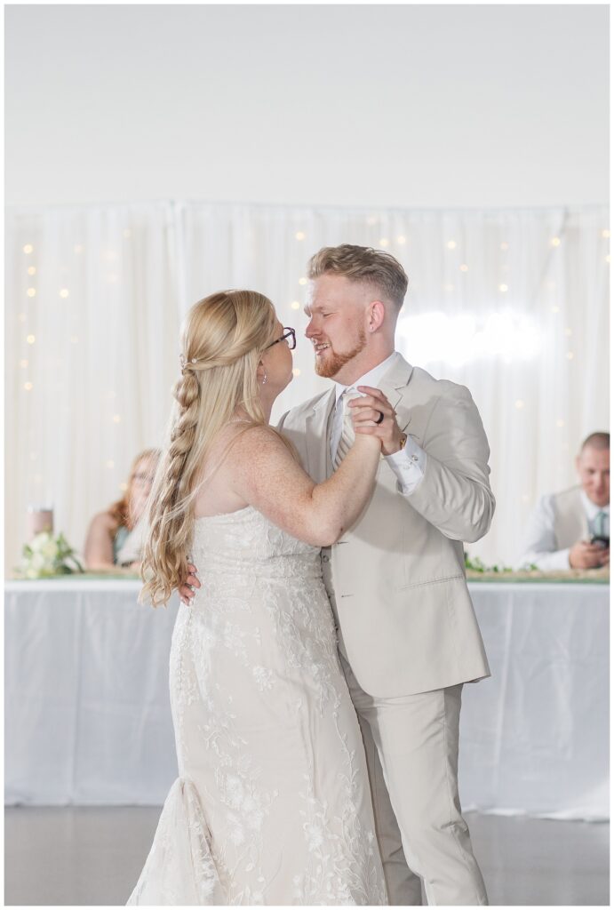 bride and groom dancing their first dance in front of the reception table in Fostoria, Ohio