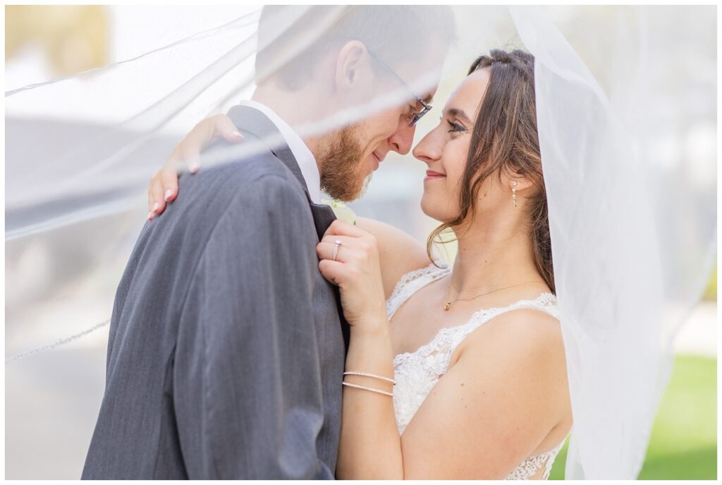 wedding couple posing under the bride's veil near The Hancock Hotel