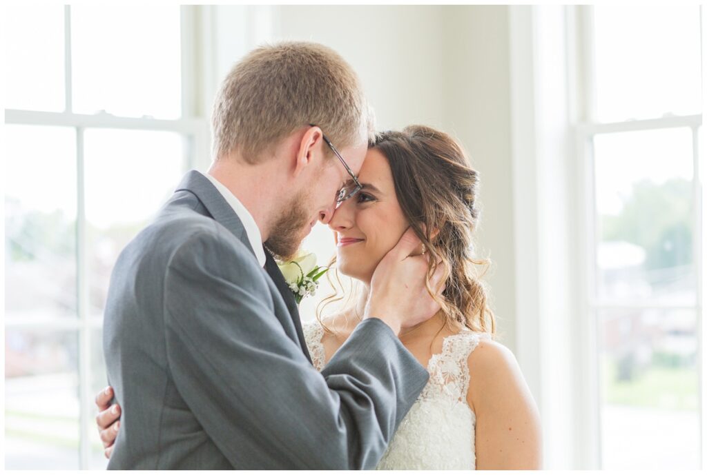 groom holding the bride's face in his hand during first look