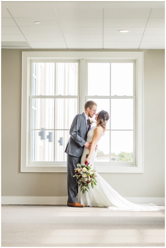 bride and groom posing in front of a large window at The Hancock Hotel