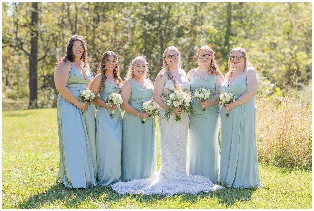 bridesmaids posing next to tall grass at Bradner Preserve