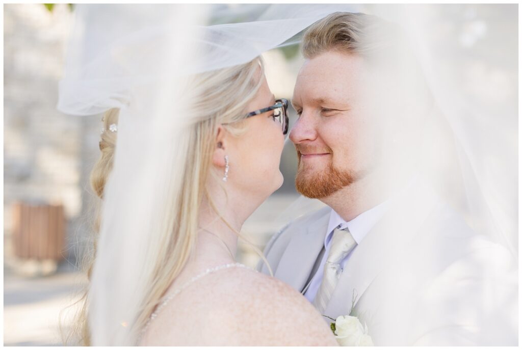 bride and groom posing under the bride's veil at Thompson Stone Hall in Ohio