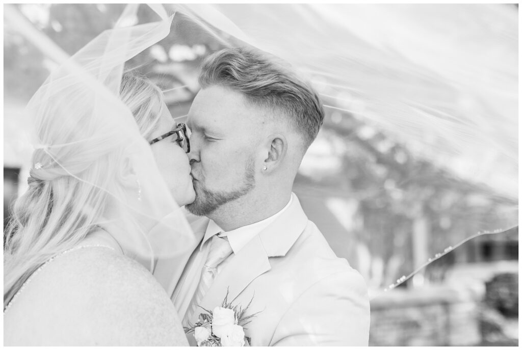 bride and groom kissing under the bride's veil at Thompson Stone Hall in Ohio