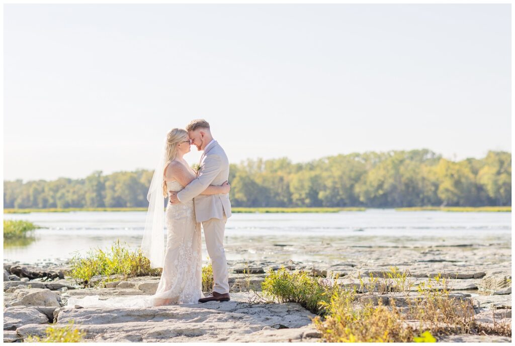 wedding couple standing on the rocks next to the river down from Otsego Park