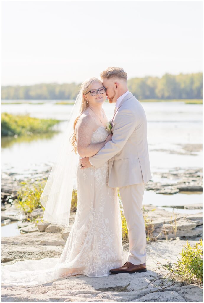 wedding couple standing on the rocks next to the river down from Otsego Park