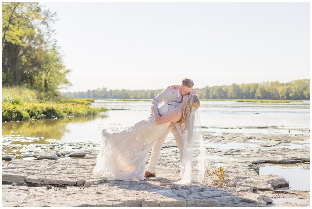 groom dipping the bride for a kiss next to the river in Bowling Green, Ohio