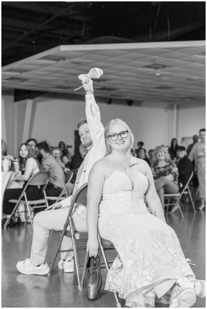 groom and bride doing the shoe game during the reception at Stacy's Place