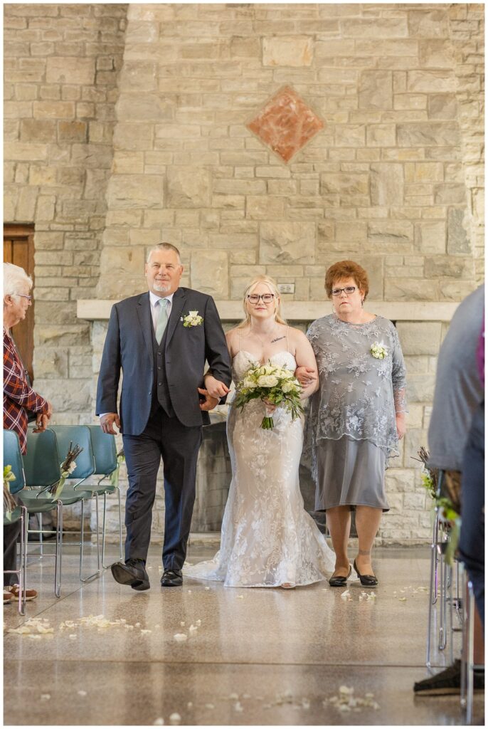 bride walking down the aisle with her parents at Thompson Stone Hall ceremony