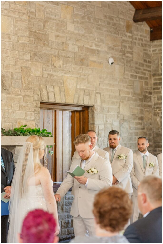 groom reading his vows to his bride during a fall wedding ceremony in Otsego Park