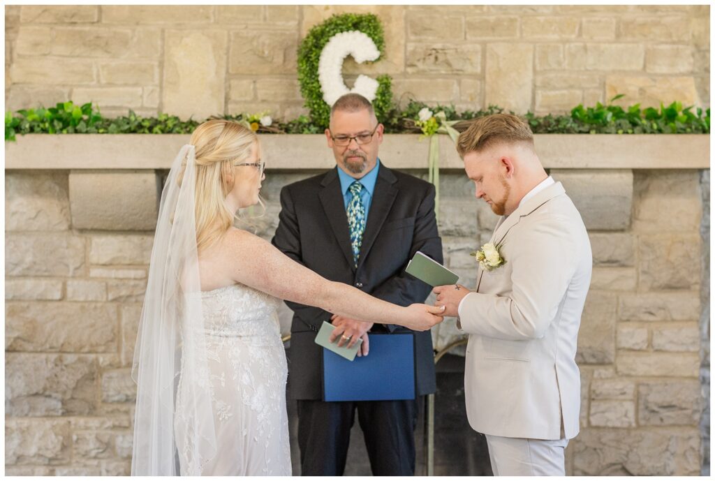 groom reading his vows to his bride during a fall wedding ceremony in Otsego Park