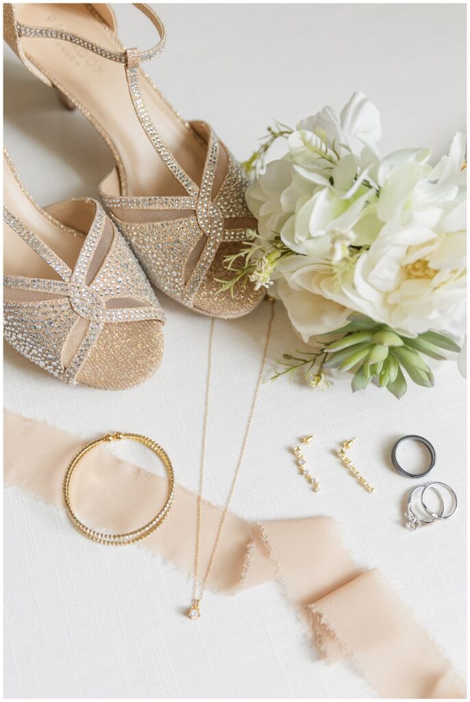 bride's wedding shoes next to jewelry and flowers on a flat lay in Ohio