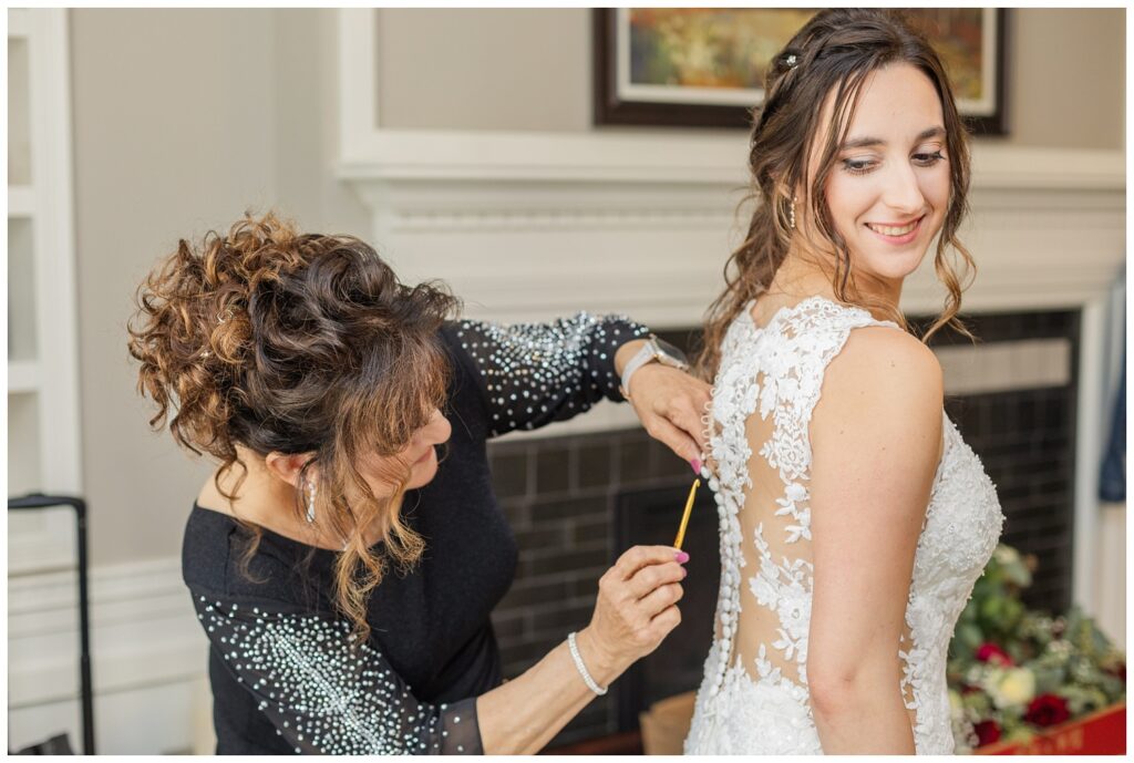 bride's mom buttoning up her dress with a hook at The Hancock Hotel