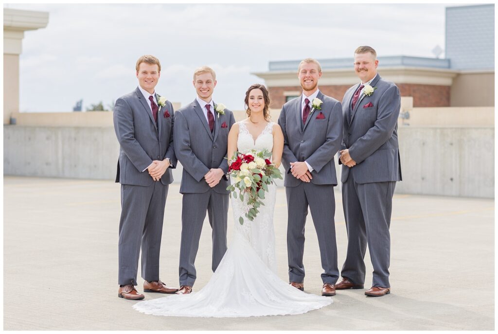 bride posing with the groomsmen on top of the parking garage in Findlay, Ohio