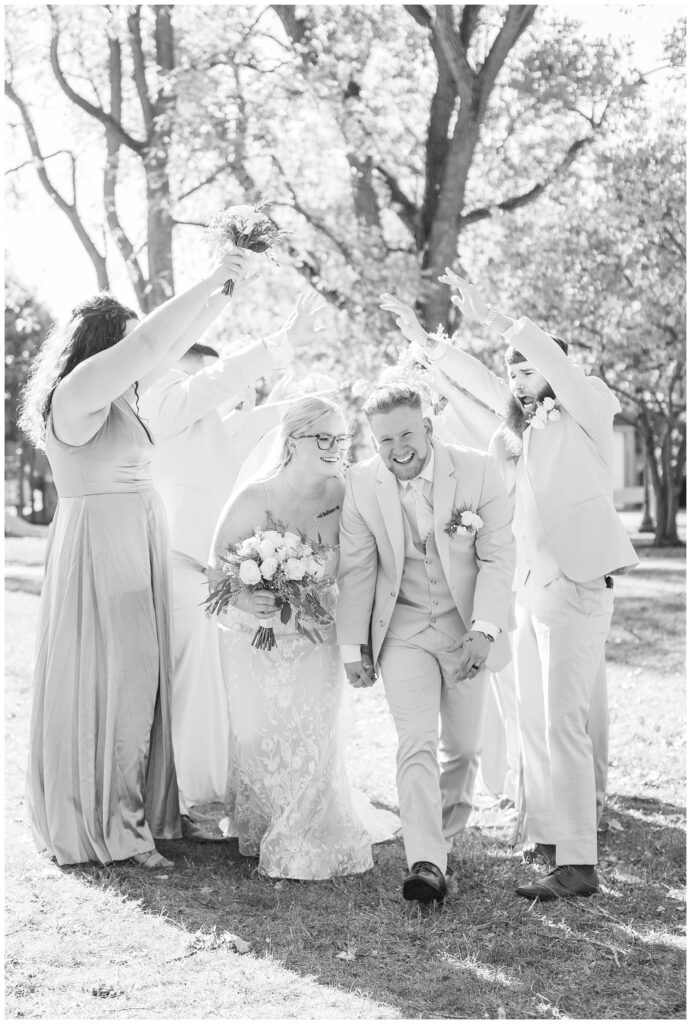 bride and groom walking under a tunnel made by a cheering wedding party