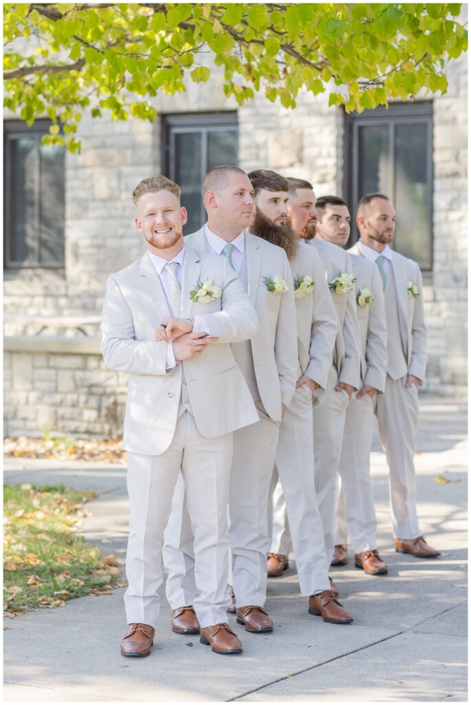 groomsmen in an offset line outside of Thompson Stone Hall in Bowling Green, Ohio