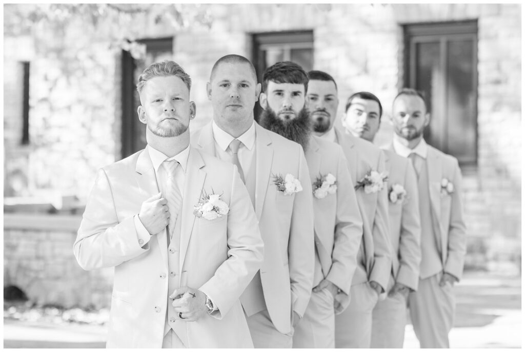 groomsmen in an offset line outside of Thompson Stone Hall in Bowling Green, Ohio