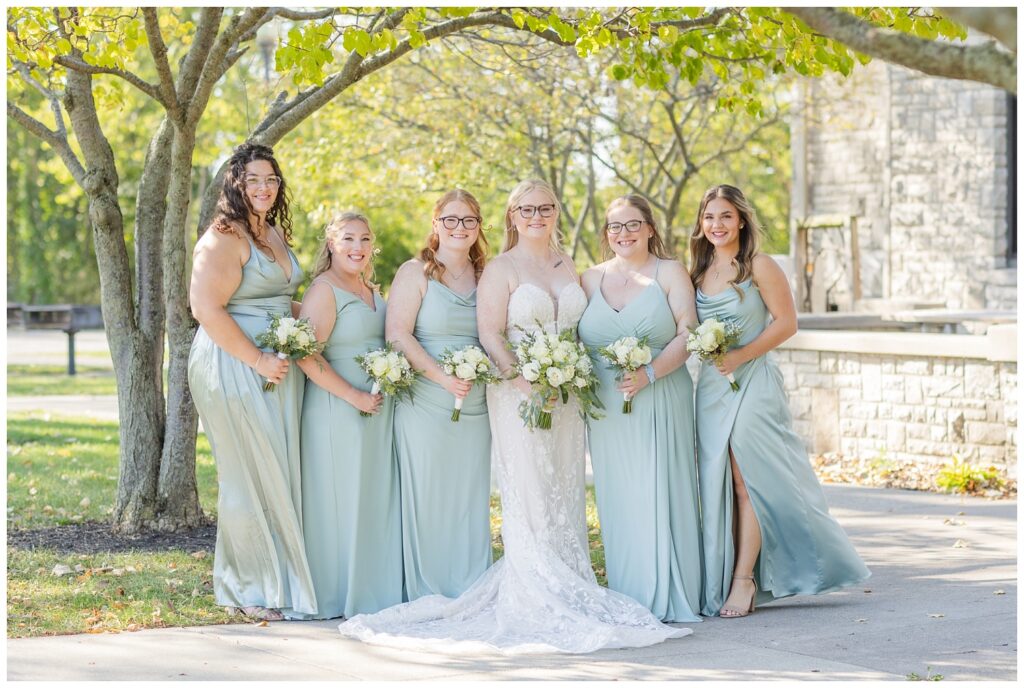 bridal party posing under a tree in Otsego Park for fall wedding 