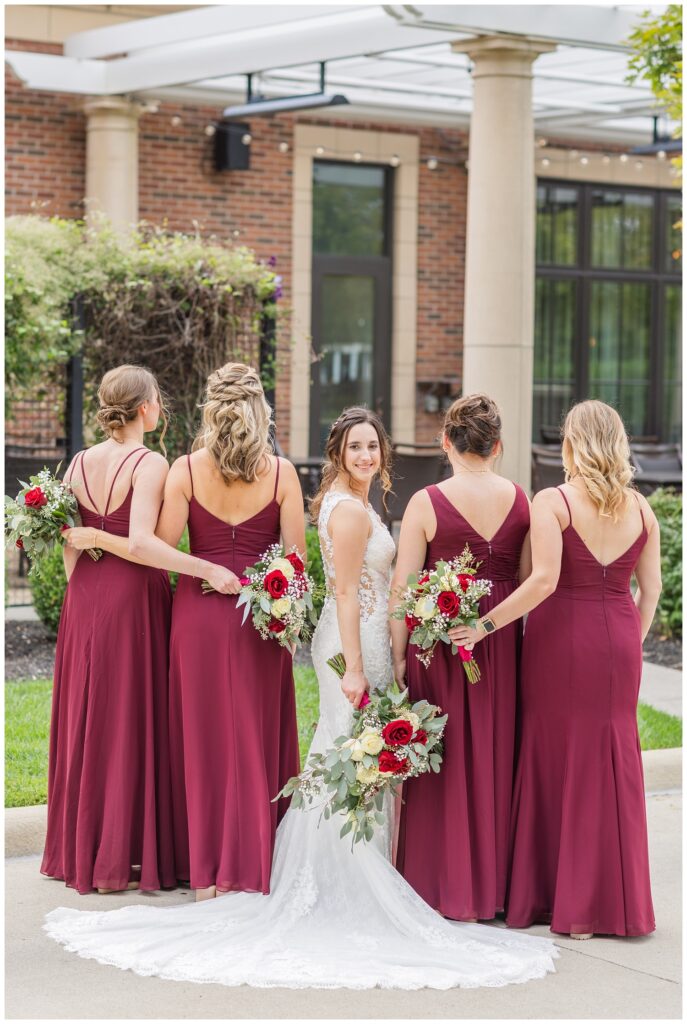 bride looking back while hugging her bridesmaids at the patio 