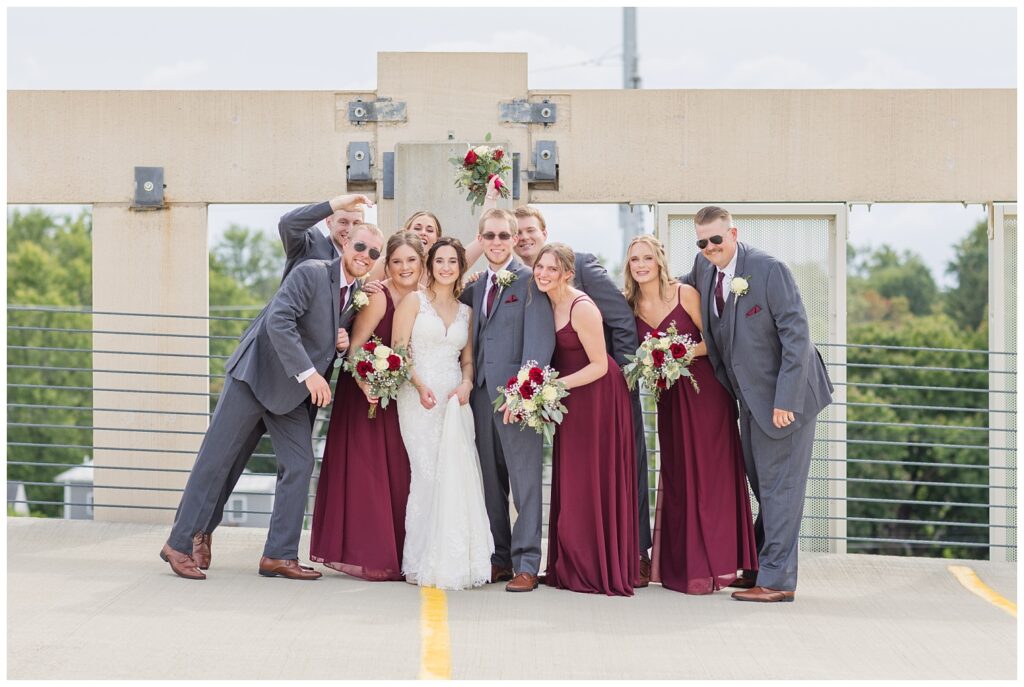 full wedding party grouped together on top of the parking garage at The Hancock Hotel