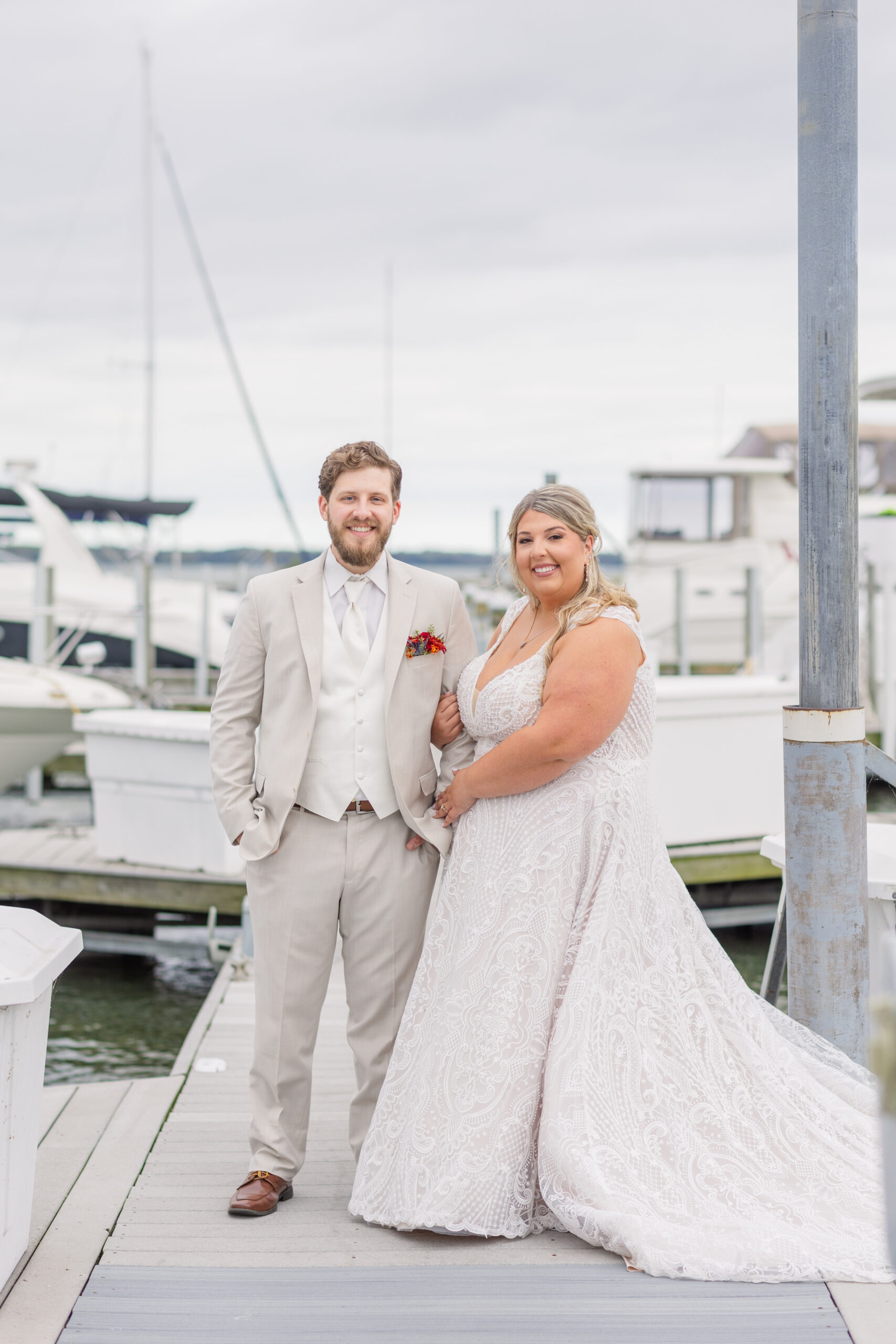 wedding couple posing next to the boats at Sandusky Yacht Club