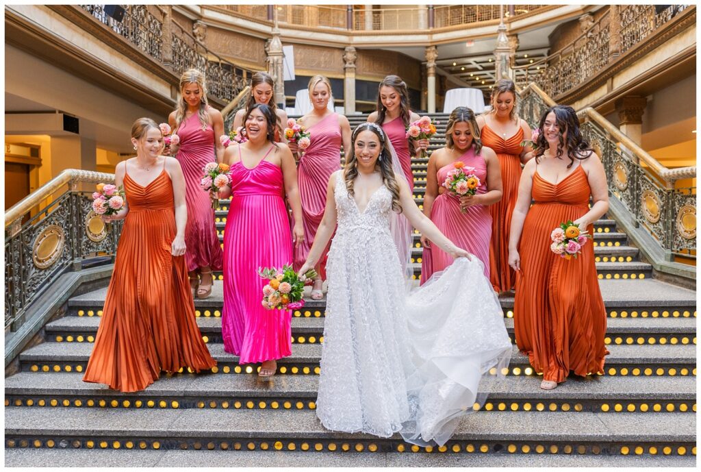 bride and her party walking down the stairs laughing and smiling