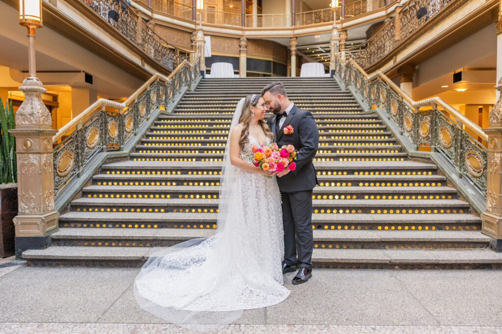 wedding couple posing at the bottom of the stairs at The Arcade in Cleveland