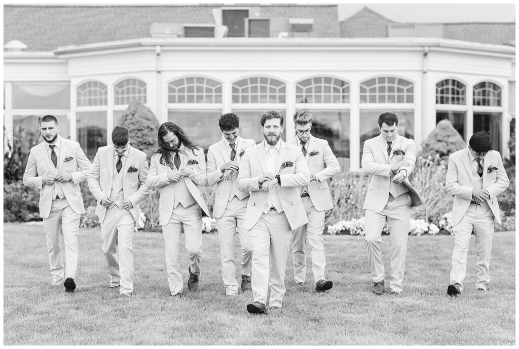 groomsmen walking together with the groom in front outside at the Sandusky Yacht Club