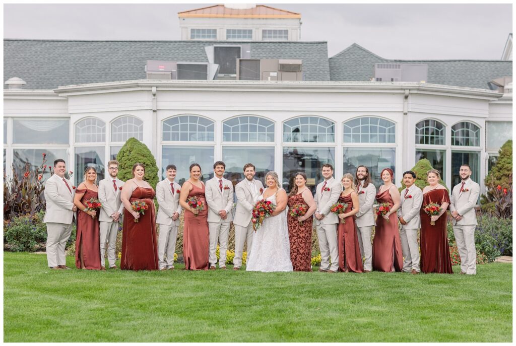 full wedding party posing in a straight line for fall ceremony at Sandusky Yacht Club