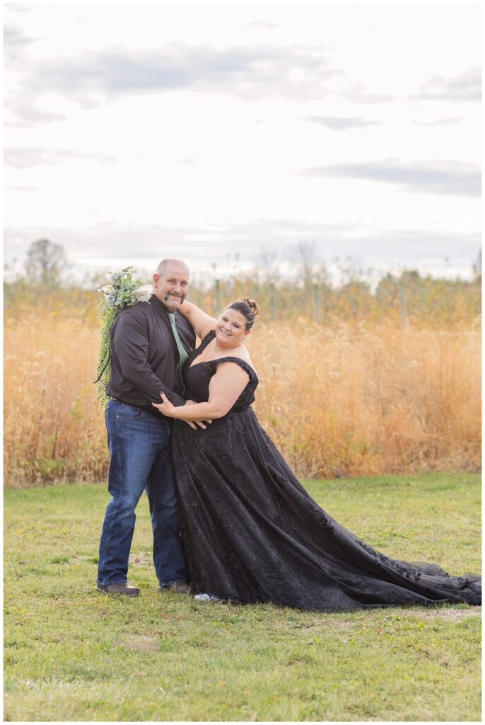 bride and groom posing for portraits outside in front of the tall field in Bucyrus, Ohio