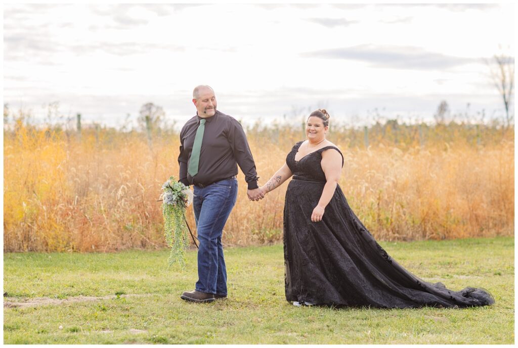 bride and groom walking together outside in front of the tall field in Bucyrus, Ohio