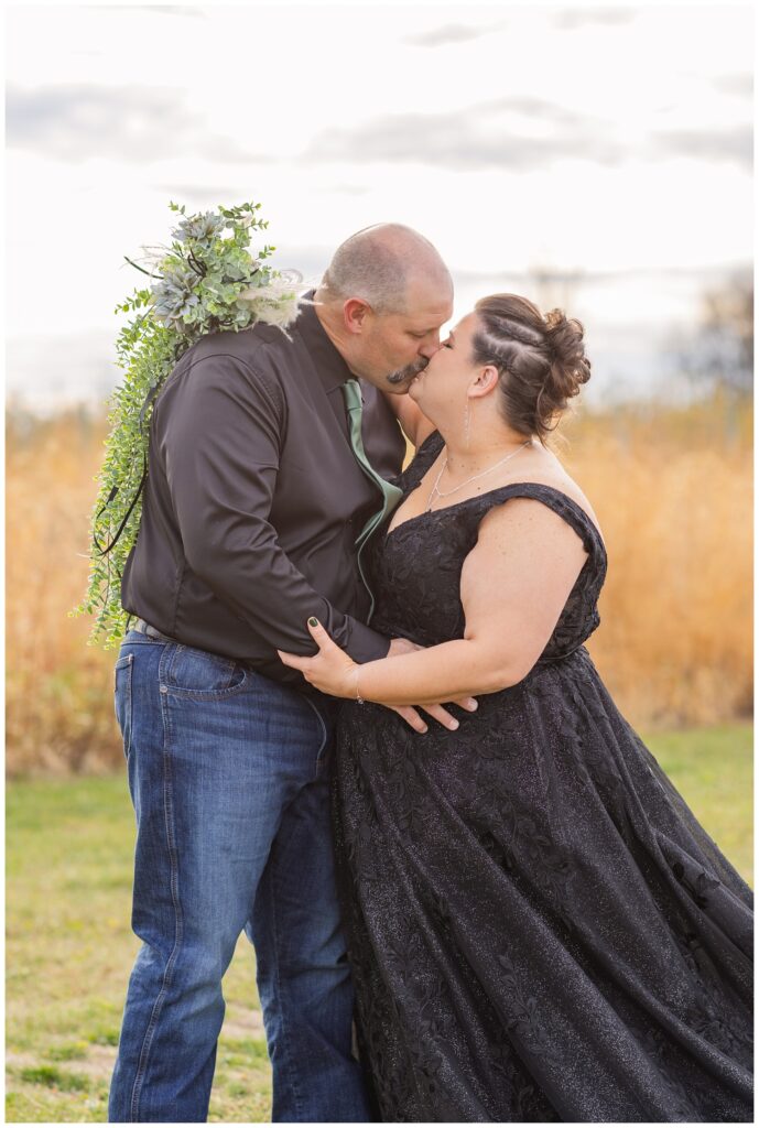 wedding couple share a kiss outside in front of the tall field in Bucyrus, Ohio