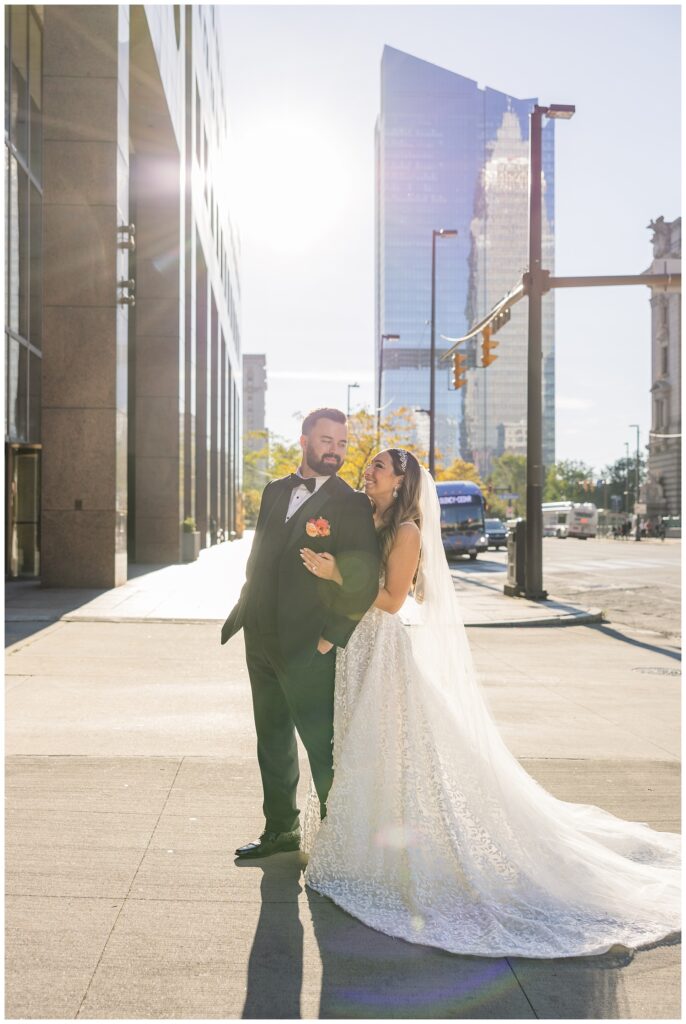 bride and groom posing on the sidewalk in downtown Cleveland