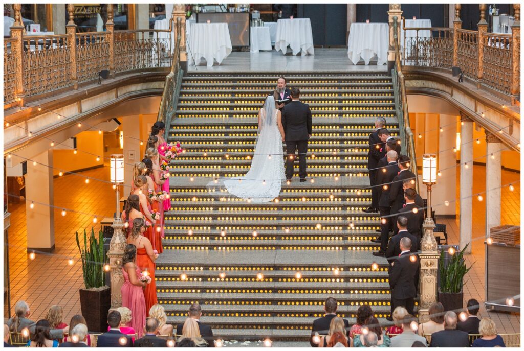 looking down from the balcony on the bride and groom getting married on the stairs